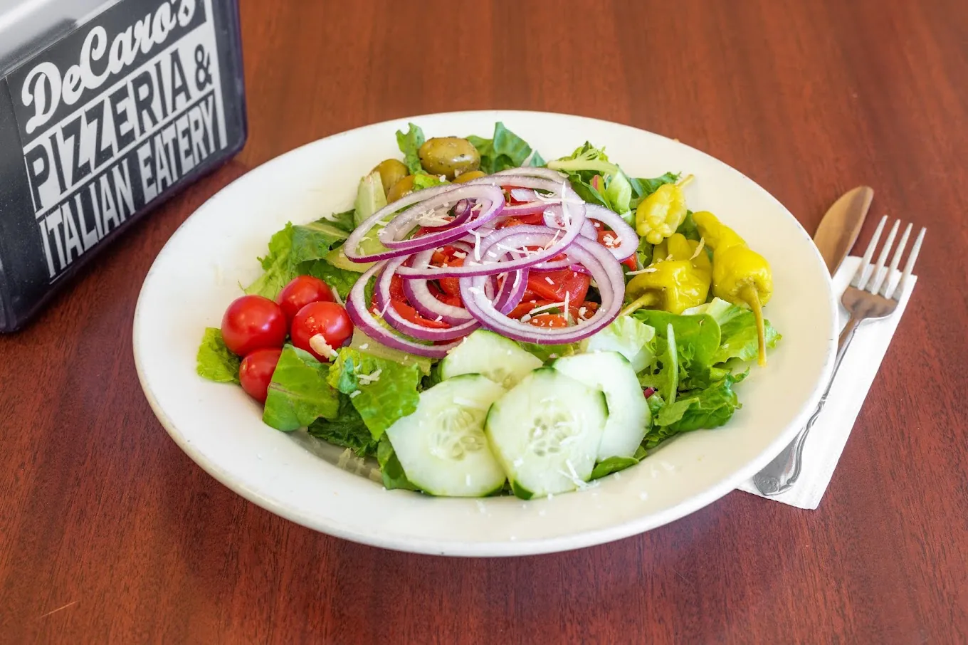 Fresh garden salad with tomatoes, cucumber, onion, olives, and peppers